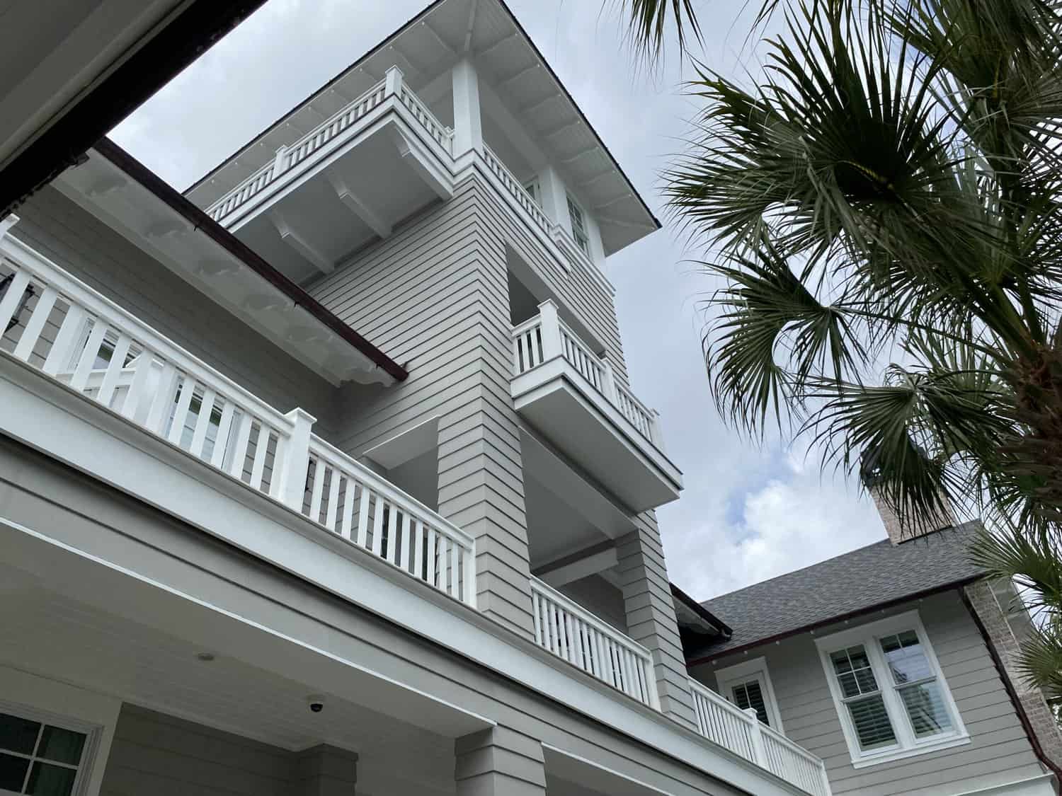 Looking up at a 2 story home that was recently painted by Coastal Home Professionals